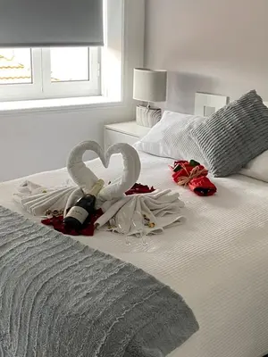 a bed with two swans made to look like hearts at Guest House Triunfo in Porto