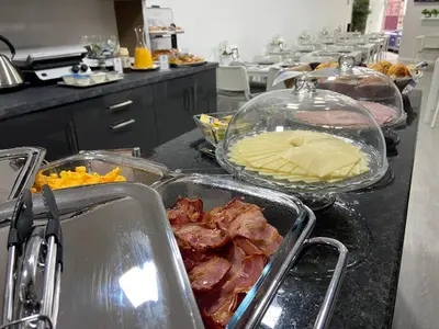 a kitchen with several trays of food on a counter at Guest House Triunfo in Porto