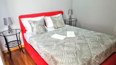 a bed with a red headboard and two tables at Cool Guesthouse in Porto