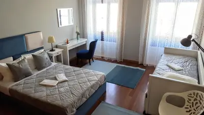 a bedroom with a bed and a desk and a chair at Cool Guesthouse in Porto