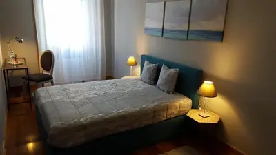 a bedroom with a bed with two lamps and a window at Cool Guesthouse in Porto