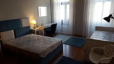 a bedroom with a bed and a desk and a chair at Cool Guesthouse in Porto