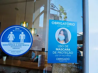 two signs in the window of a store at Poveira Hotel in Porto