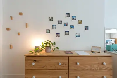 a wooden dresser with photos on the wall at Light Blue Apartment in Porto