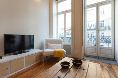 a living room with a flat screen tv and a chair at Loft Ribeira - 3px - Spacious Flat in Porto