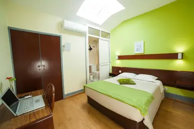 a bedroom with a bed and a laptop on a desk at Hotel Estoril Porto in Porto