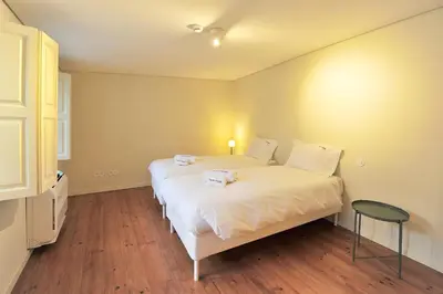 a bedroom with a large white bed and a table at FLH Oporto Captain House in Porto