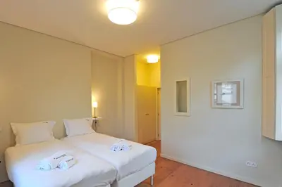 a bedroom with a white bed with towels on it at FLH Oporto Captain House in Porto