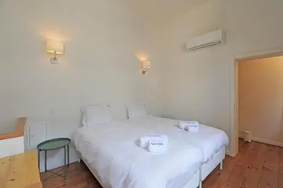 a bedroom with a white bed with two boxes on it at FLH Oporto Captain House in Porto