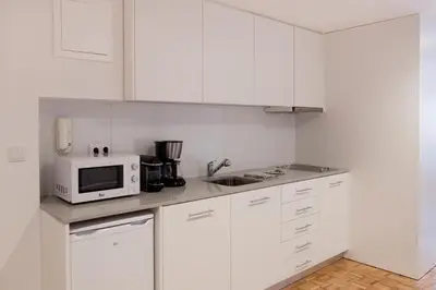 a kitchen with white cabinets and a microwave at Citybreak-apartments Patio in Porto