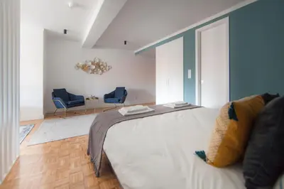 a bedroom with a bed and two blue chairs at Citybreak-apartments Patio in Porto