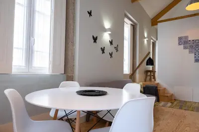 a white dining room with a white table and white chairs at Alda's Vintage Apartments with Free Parking in Porto