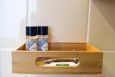 a wooden shelf with a hair dryer and three cups at Alda's Vintage Apartments with Free Parking in Porto