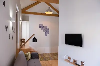 a living room with a couch and a tv on the wall at Alda's Vintage Apartments with Free Parking in Porto