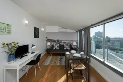 a living room with a desk and a large window at naBaixa Apartments in Porto