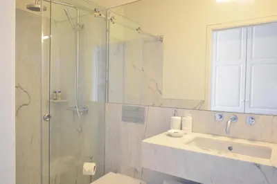 a bathroom with a glass shower and a sink at YOUROPO - Market in Porto