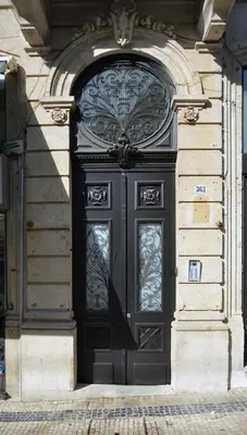 a black door on the side of a building at YOUROPO - Market in Porto