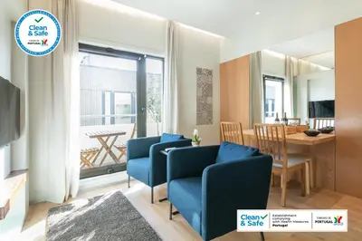 a living room with two blue chairs and a table at Inn Oporto Downtown New Apartments in Porto