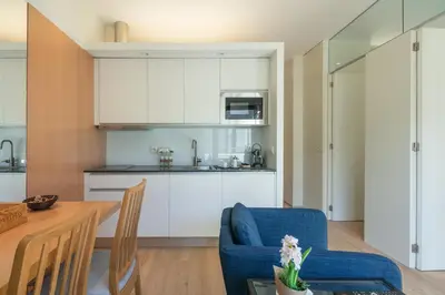 a kitchen and living room with a table and chairs at Inn Oporto Downtown New Apartments in Porto