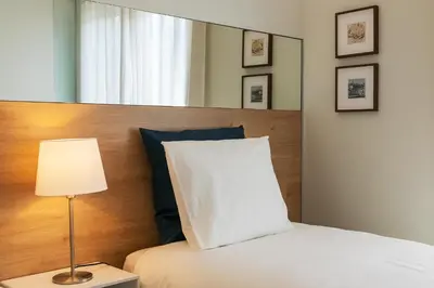 a bed with a white pillow and a lamp at Inn Oporto Downtown New Apartments in Porto