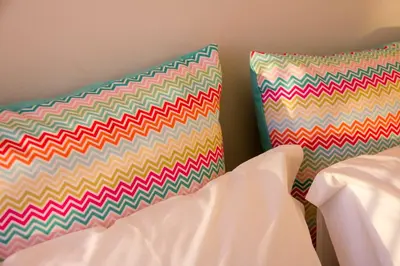 two colorful pillows are sitting on a bed at MH Duo in Porto