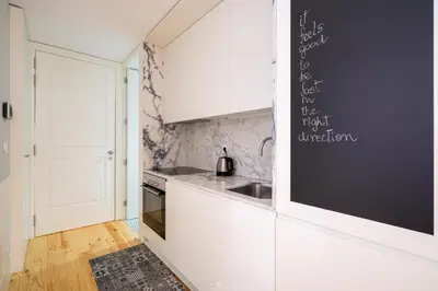 a kitchen with white cabinets and a black wall at Best Of Porto Apartment - BOP in Porto