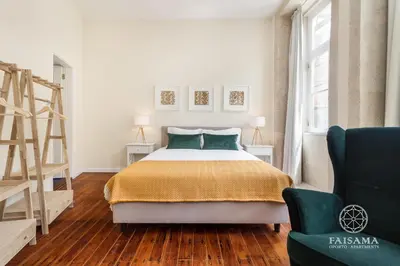 a bedroom with a bed and a ladder and a chair at FAISAMA • Porto Apartments in Porto