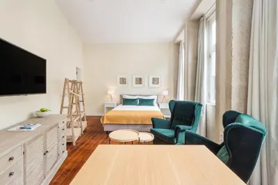 a room with a bed and a table and chairs at FAISAMA • Porto Apartments in Porto