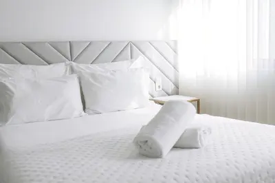 a white bed with white pillows and a towel on it at Alma Invicta Alegria in Porto