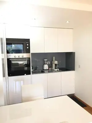 a kitchen with white cabinets and a stove top oven at Maestro Appartment in Porto