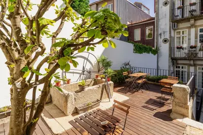 a patio with a tree and a table and chairs at Porto Lounge Hostel & Guesthouse by Host Wise in Porto