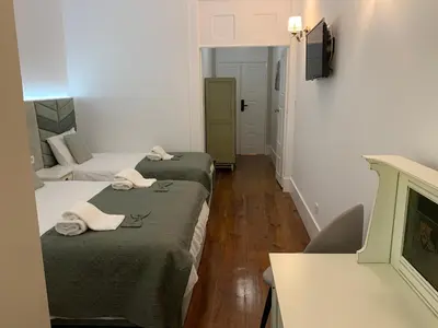a room with two beds with towels on them at A Portuguesa Guest House in Porto