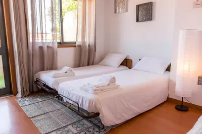 two twin beds in a room with a window at Sunset Relaxing Apt with terrace, parking & bikes in Porto