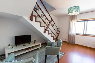 a living room with a tv and a staircase at Sunset Relaxing Apt with terrace, parking & bikes in Porto