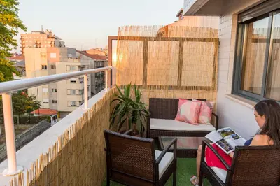 a woman sitting in chairs on a balcony at Sunset Relaxing Apt with terrace, parking & bikes in Porto