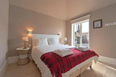 a bedroom with a bed with a red blanket and a window at Oporto AAA - Almada Aliados Apartment in Porto