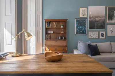 a living room with a table and a couch at Central location with garden & equipped kitchen in Porto