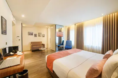 a hotel room with a bed and a desk with a laptop at Hotel Moon & Sun Porto in Porto