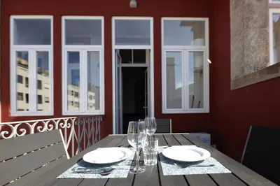 a wooden table with plates and glasses on a balcony at FLH Porto Elegant Flat with Terrace in Porto