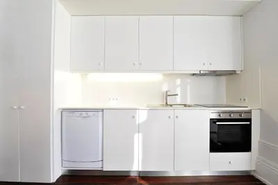 a kitchen with white cabinets and a sink and a dishwasher at FLH Porto Elegant Flat with Terrace in Porto