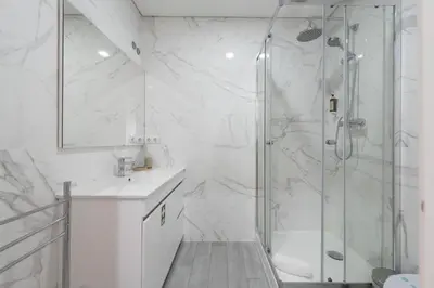a white bathroom with a shower and a sink at Bruno's Downtown Apartment in Porto