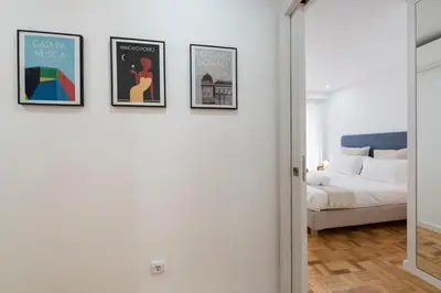 a bedroom with three framed pictures on the wall and a bed at Bruno's Downtown Apartment in Porto