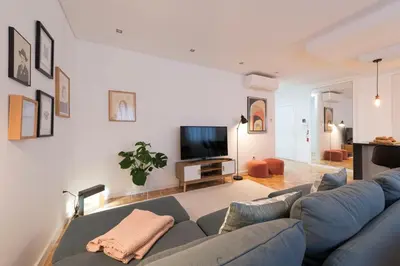 a living room with a blue couch and a tv at Bruno's Downtown Apartment in Porto