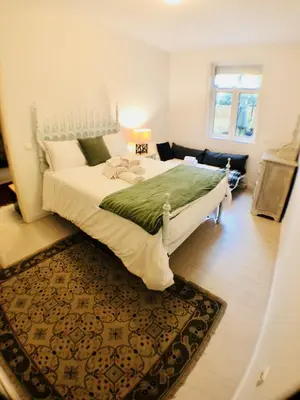 a bedroom with a large white bed with a rug at BS VILLAS RC PORTO in Porto