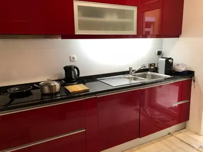 a kitchen with red cabinets and a sink at BS VILLAS RC PORTO in Porto