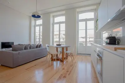 a kitchen and living room with a couch and a table at Downtown Spacious Studio in Porto