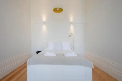 a white room with a bed with two pillows at Downtown Spacious Studio in Porto