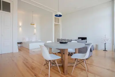 a dining room with a table and white chairs at Downtown Spacious Studio in Porto