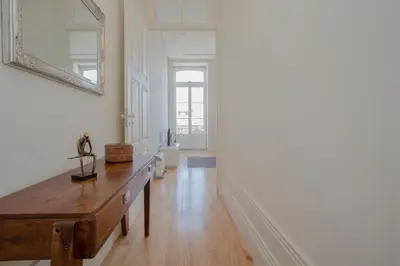 a living room with a wooden table and a mirror at Downtown Spacious Studio in Porto
