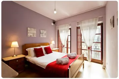 a bedroom with a large bed with red pillows at Porto Village Inn in Porto